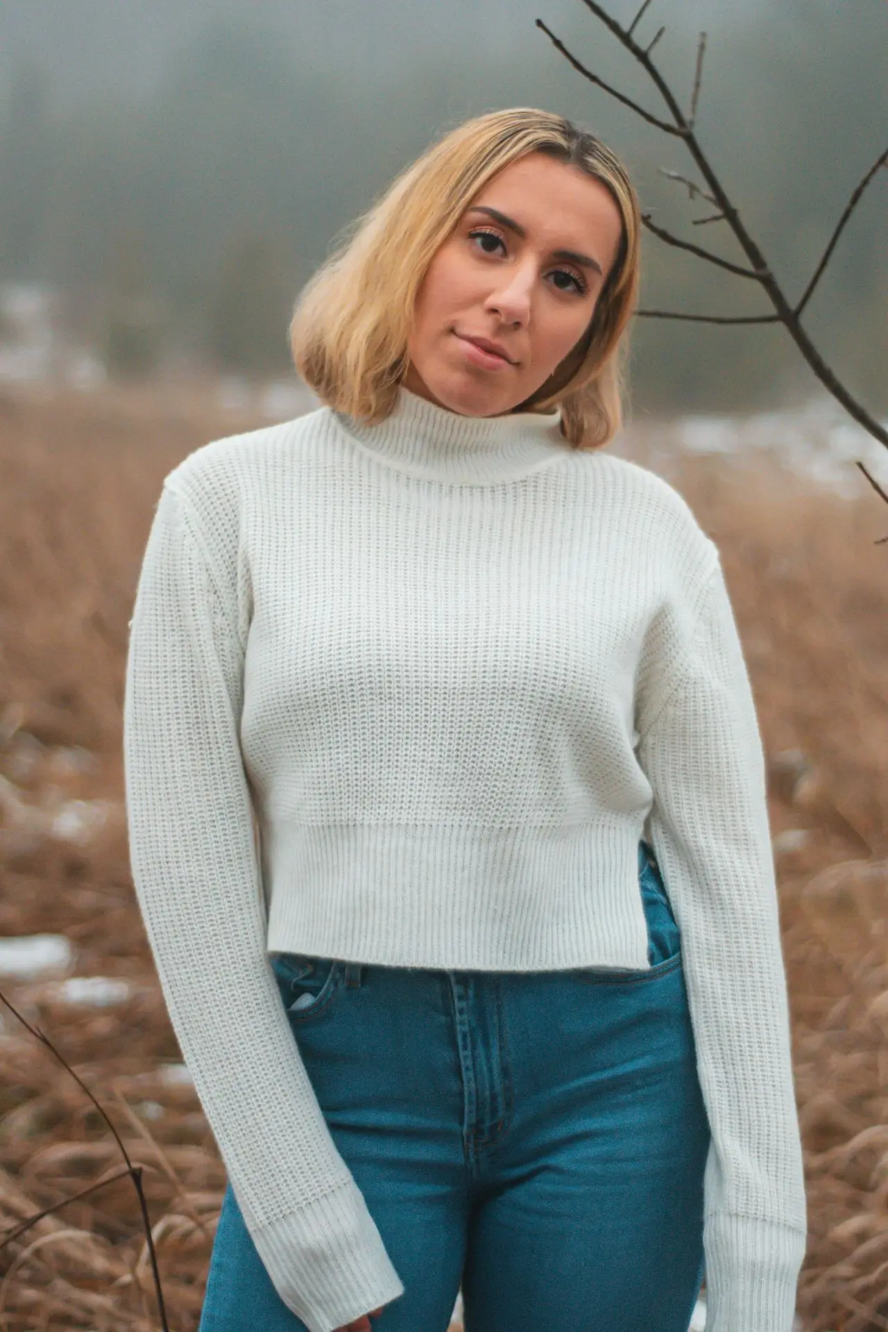 portrait photography of woman wearing white sweater and blue denim jeans